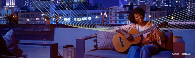 A woman playing guitar on a rooftop